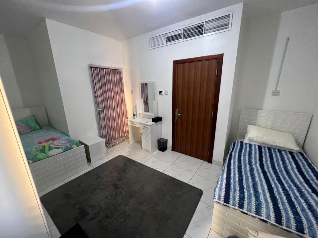 阿布扎比Furnished Regular Room in shared Apartment的卧室配有床、水槽和门