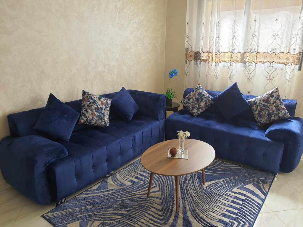 梅克内斯Appartement Dar Meknès的客厅配有蓝色的沙发和桌子