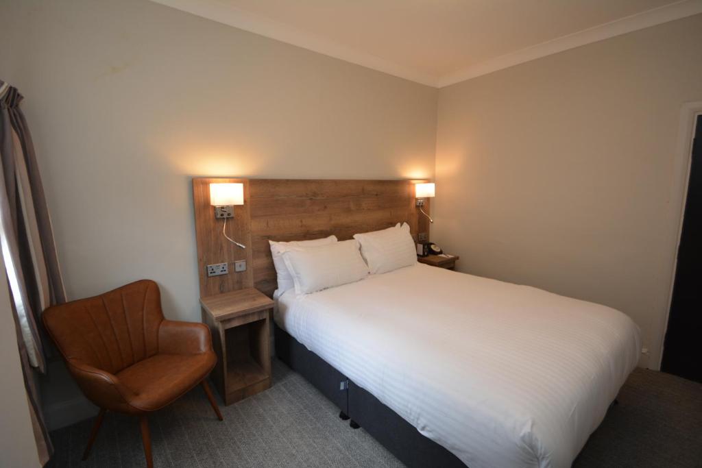 拉格比橄榄球酒店 的配有一张床和一把椅子的酒店客房