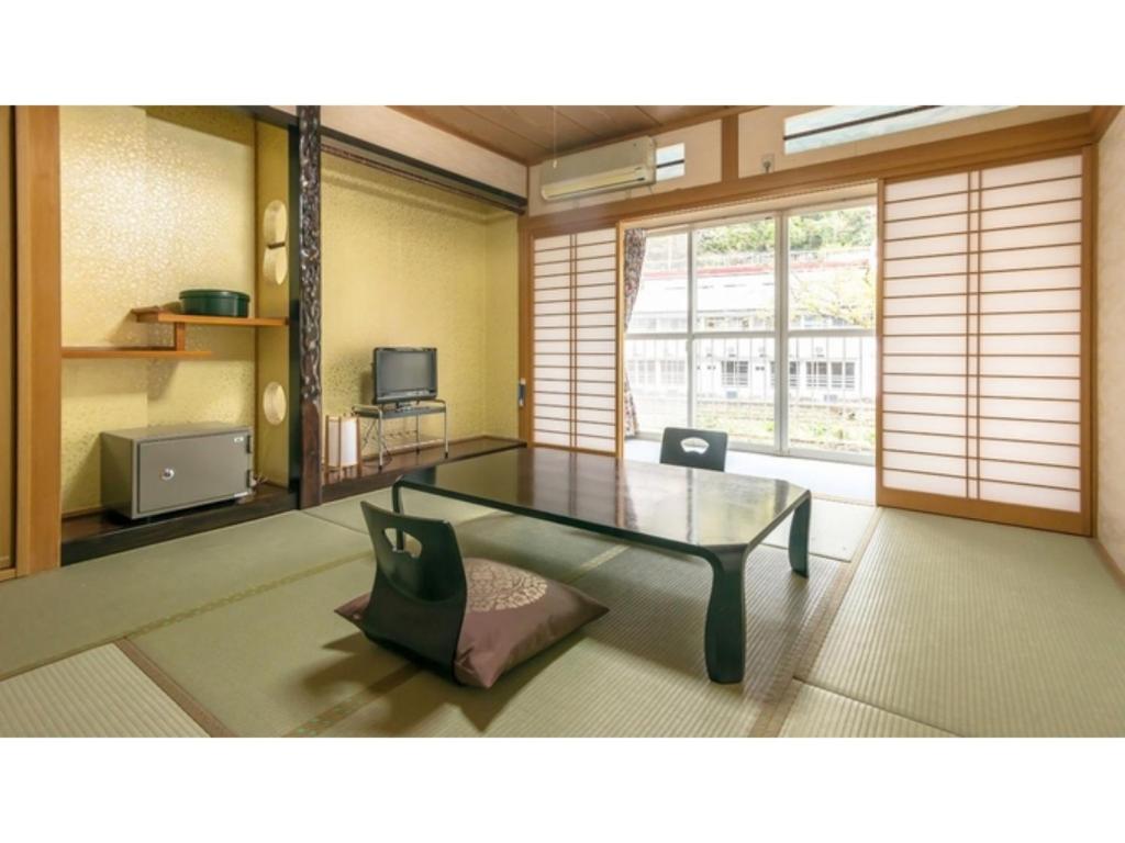 雾岛市Myoken Onsen Nemu - Vacation STAY 20857v的客厅配有玻璃桌和椅子