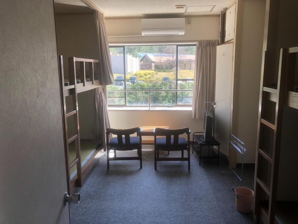 鸟取市Guesthouse Sunaen - Vacation STAY 49061v的客房设有桌椅和窗户。