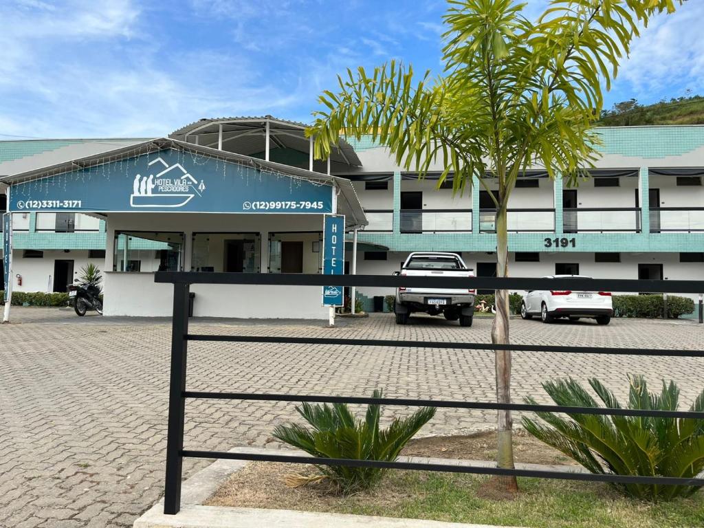 阿帕雷西达Hotel Vila dos Pescadores的前面有棕榈树的建筑