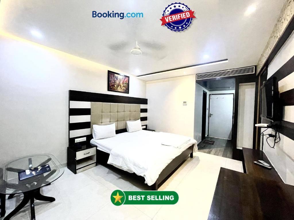 瓦拉纳西HOTEL P PALACE ! VARANASI fully-Air-Conditioned-hotel lift-and-Parking-availability, near Kashi Vishwanath Temple, and Ganga ghat的一间卧室配有一张床、一张书桌和一台电视。