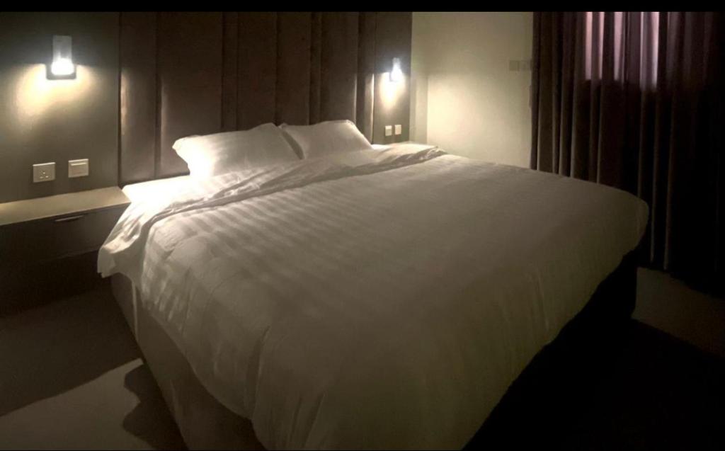 阿哈达نايس فور الهدا的卧室里一张大白色的床,有两盏灯