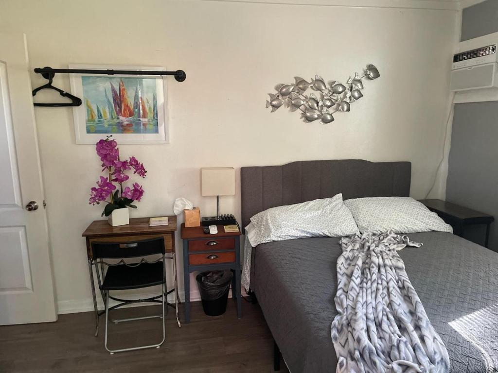 坦帕Lovely Studio Apartment with Kitchenette.的一间卧室配有一张床和一张桌子及床头柜