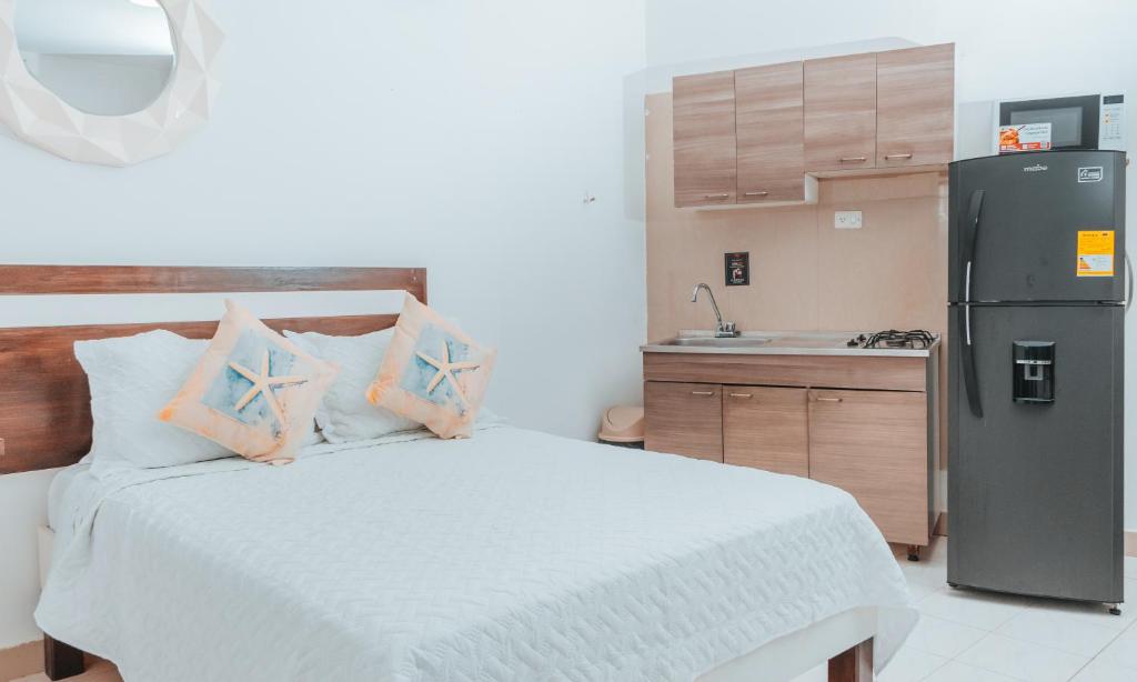 圣安德烈斯APARTAHOTEL BEIRUT INN的一间卧室配有一张床和一台冰箱