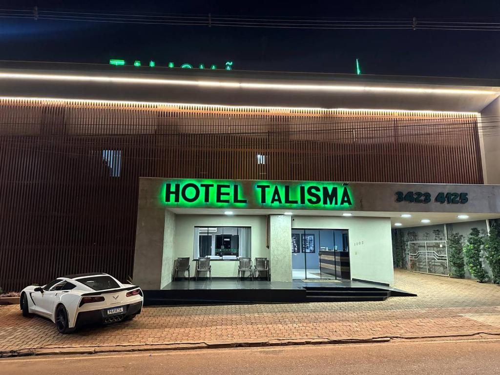龙多诺波利斯Hotel Talismã的停在酒店大楼前的白色汽车