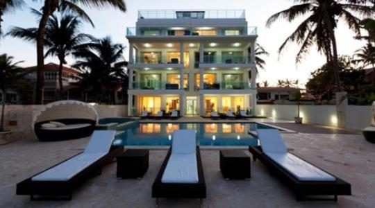 喀巴里特水印豪华海滨公寓 的一座大房子,前面设有一个游泳池