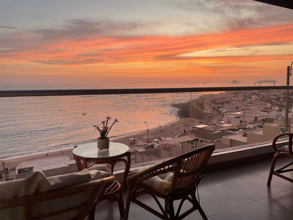 蓬塔赫尔莫萨Apartamento Playa Señoritas的阳台配有桌椅,享有海景。