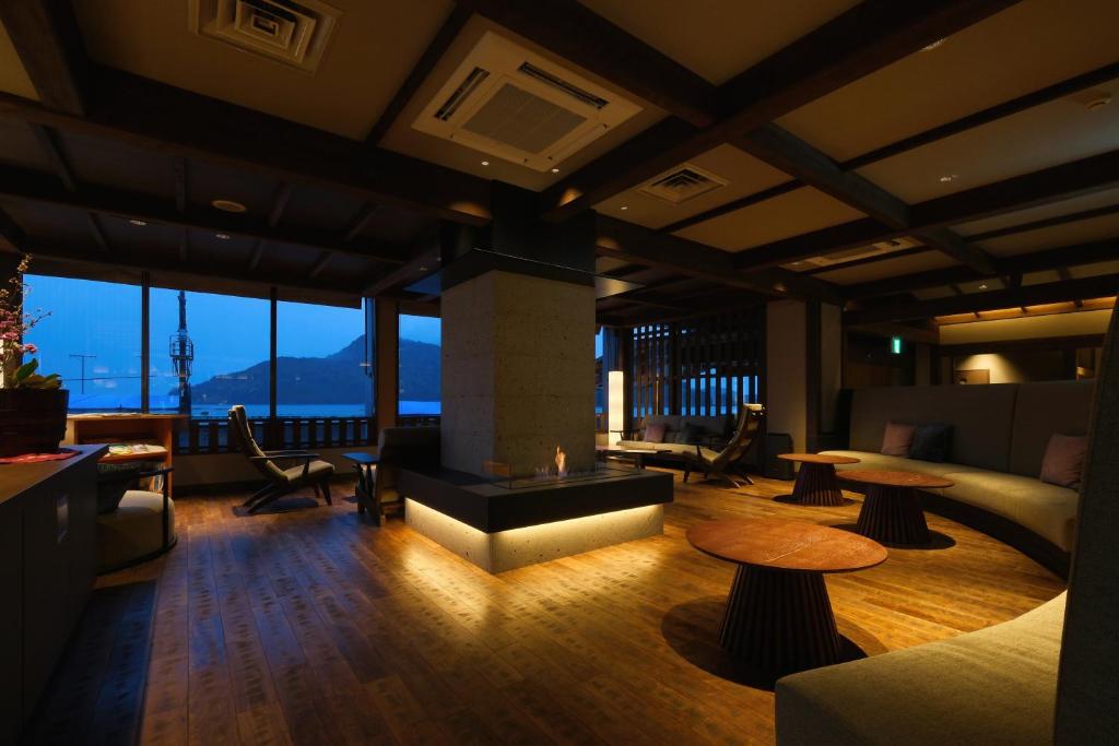 福山尾道景胜馆涟亭酒店的客厅设有壁炉、桌子和窗户。