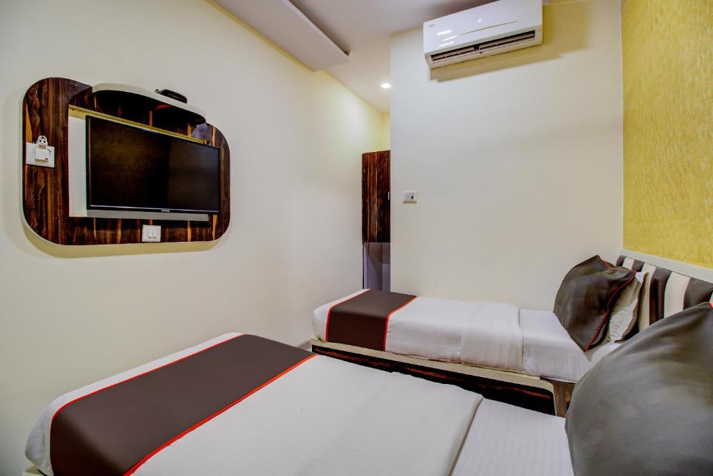 孟买Golden Tulipz Boutique的小房间设有床铺和电视