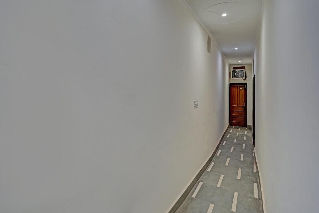 ShāhdaraOYO Hotel Jmd Residency的一条带白色墙壁和门的走廊