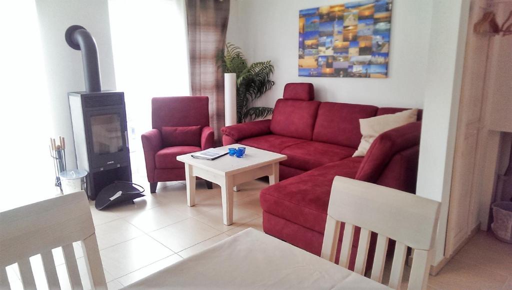 格洛韦Haus Annette的客厅配有红色的沙发和桌子