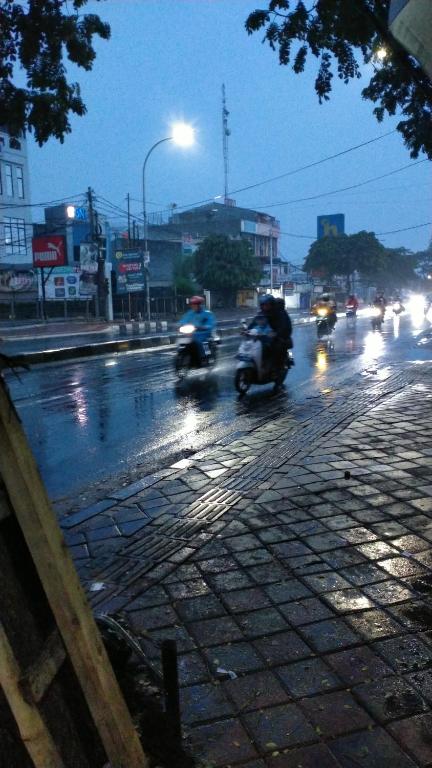 BulakIfrazim home peninggilan的一群摩托车在雨中沿着街道行驶