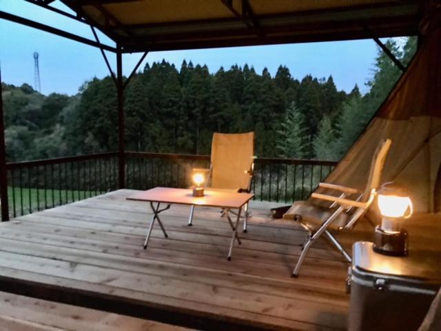 Inashikiビラ里山双林的一个带帐篷、椅子和蜡烛的甲板