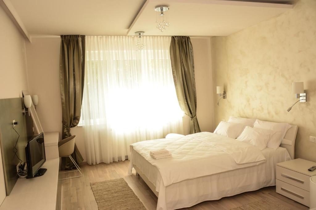 沙巴茨Apartment Venera A&M的卧室配有白色的床和窗户。