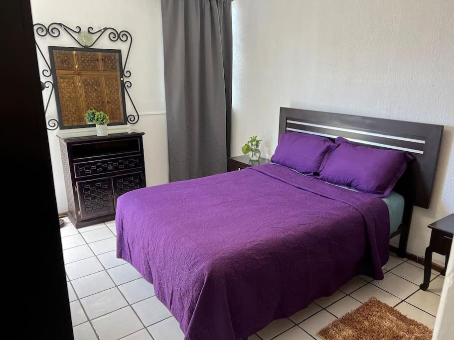 乌鲁阿潘Caza en zona residencial的一间卧室配有一张紫色的床和一个壁炉