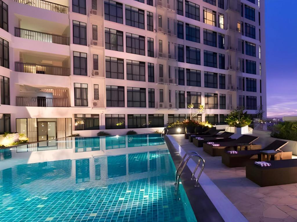 古晋古晉馨乐庭酒店的一座游泳池,在晚上在建筑物前