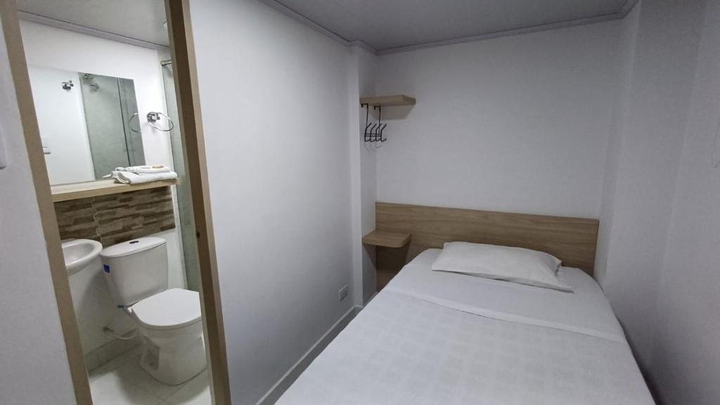 马尼萨莱斯Hotel Adel的小房间设有床和卫生间