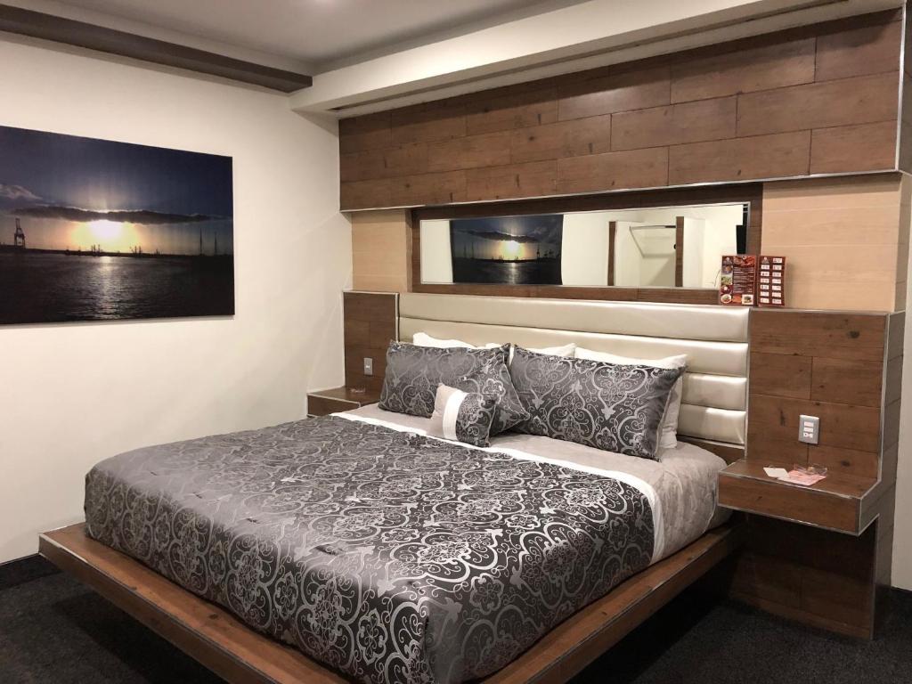 恩塞纳达港HOTEL BUGAMBILIAS的一间卧室配有一张大床和木制床头板