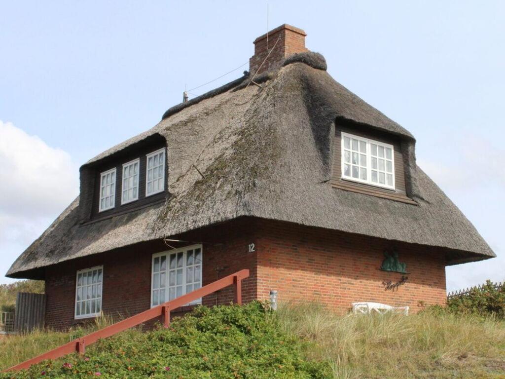 兰图姆Haus Hoppel - FeWo ground floor的田野上茅草屋顶的房子