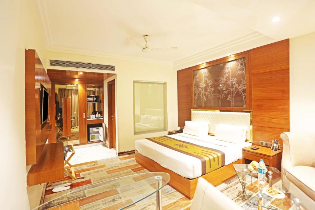 新德里Hotel Aerotech Near Delhi Airport的一间卧室设有一张床和一间客厅。