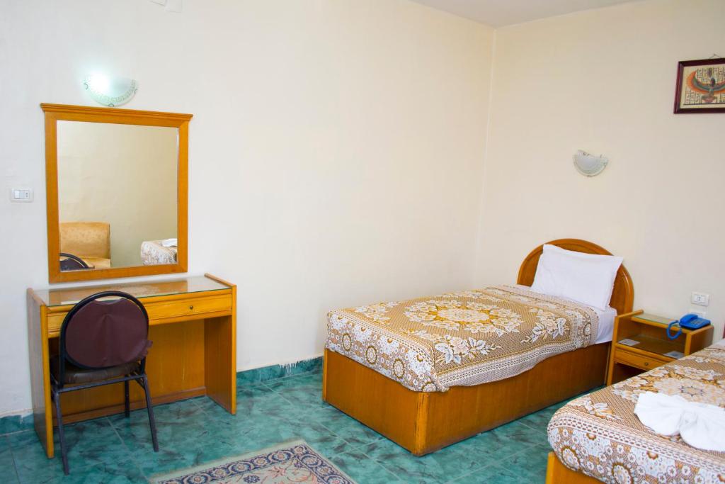 亚历山大Semiramis hotel的一间卧室配有两张床、一张桌子和一面镜子