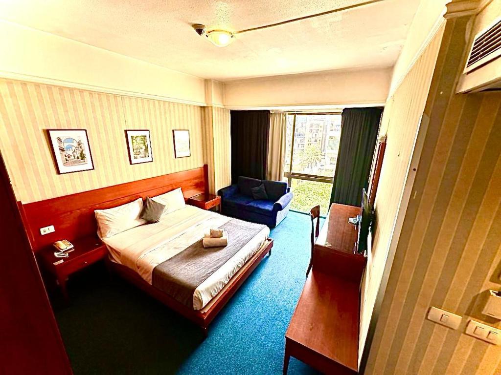 贝鲁特凯撒公园酒店的配有一张床和一把椅子的酒店客房