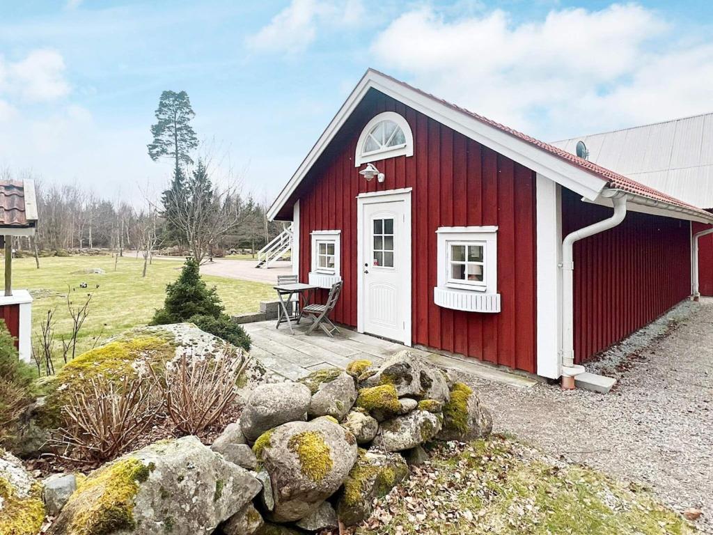 韦克舍Holiday home VÄXJÖ II的一座红白的建筑,有一堆岩石