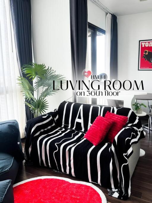 坤敬HMJ4 2BR stylish apartment on 36th floor KKC City center的客厅配有黑色和白色的床和红色枕头