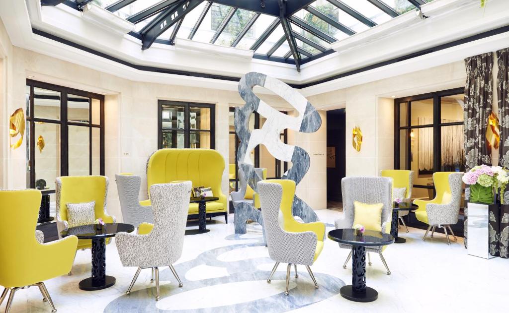 巴黎巴黎布尔甘地酒店的一间带桌椅和雕塑的房间