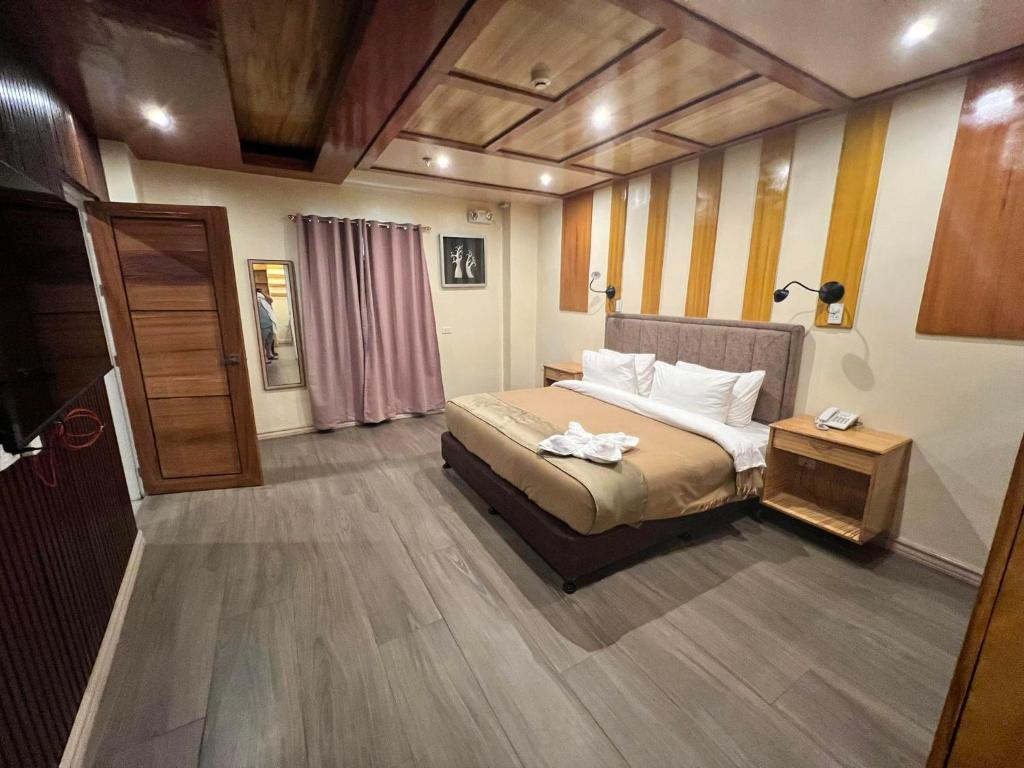 帕加迪安Raim Hotel的一间卧室配有一张床和一张桌子,上面配有毛巾