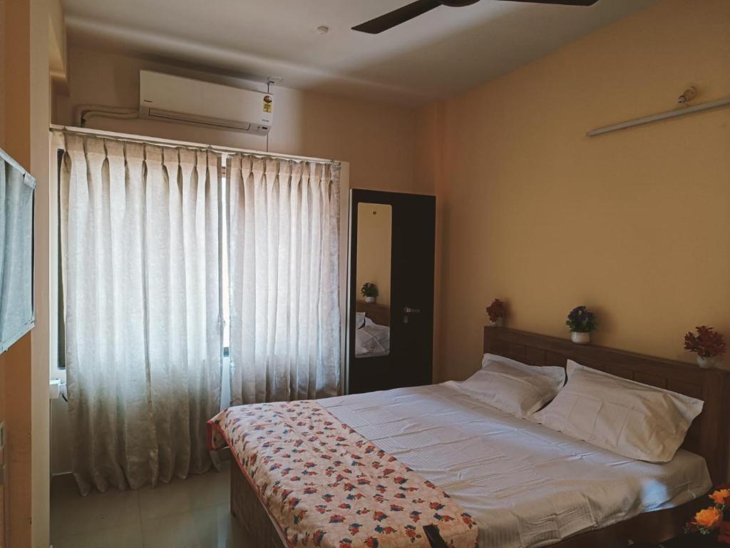 拉特纳吉里Great Hornbill Homestay, Ratnagiri的一间卧室设有一张大床和一个窗户。