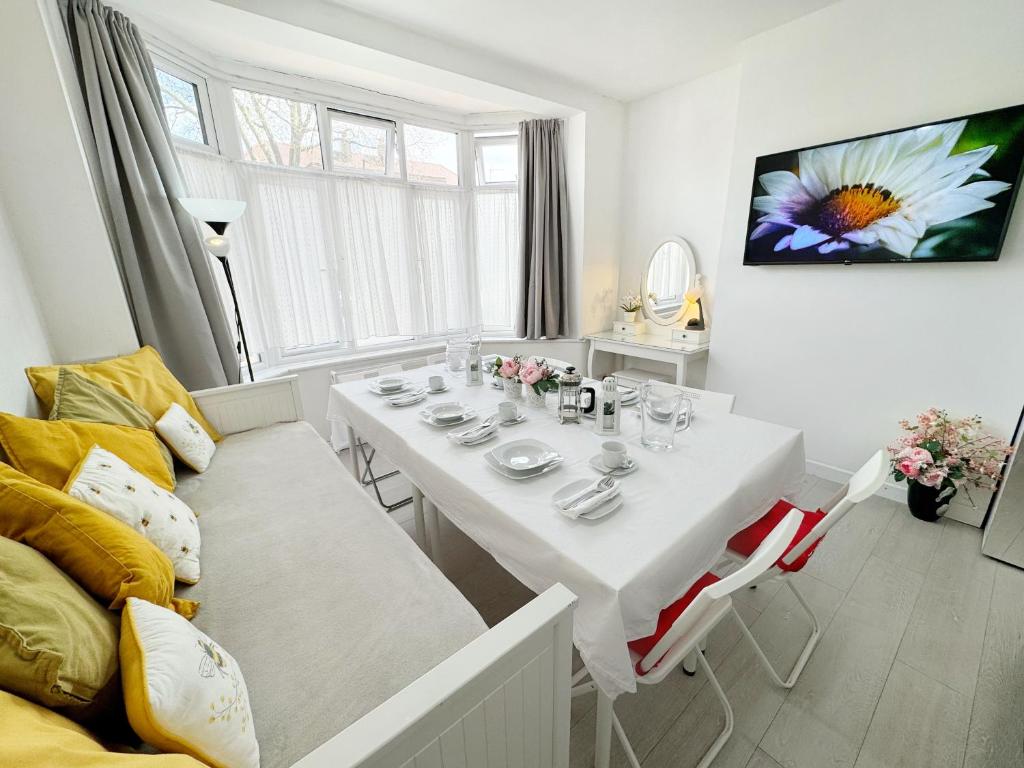 伦敦Luxurious House near Excel- Air Conditioning, 9 Beds, 2 Baths, Garden, fast WiFi的白色的用餐室配有白色的桌椅