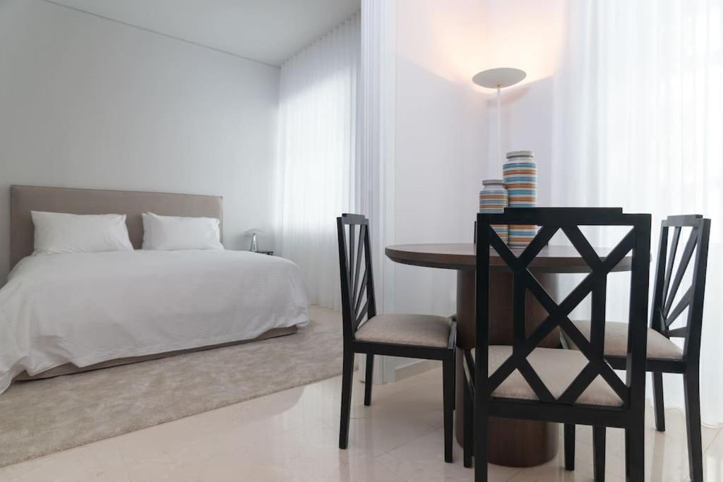 雅典LuxLoom Athens next to Hilton的卧室配有一张床和一张桌子及椅子
