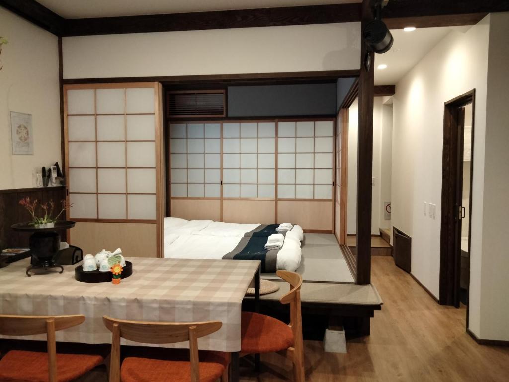 京都秋桜館Cosmos的配有一张床和一张桌子及椅子的房间