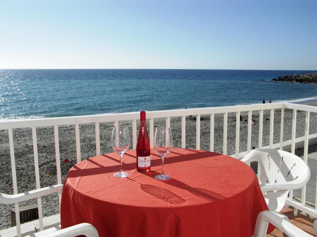 内尔哈卢阿尔托雷西利亚公寓的一张桌子,上面有一瓶葡萄酒和眼镜,放在沙滩上
