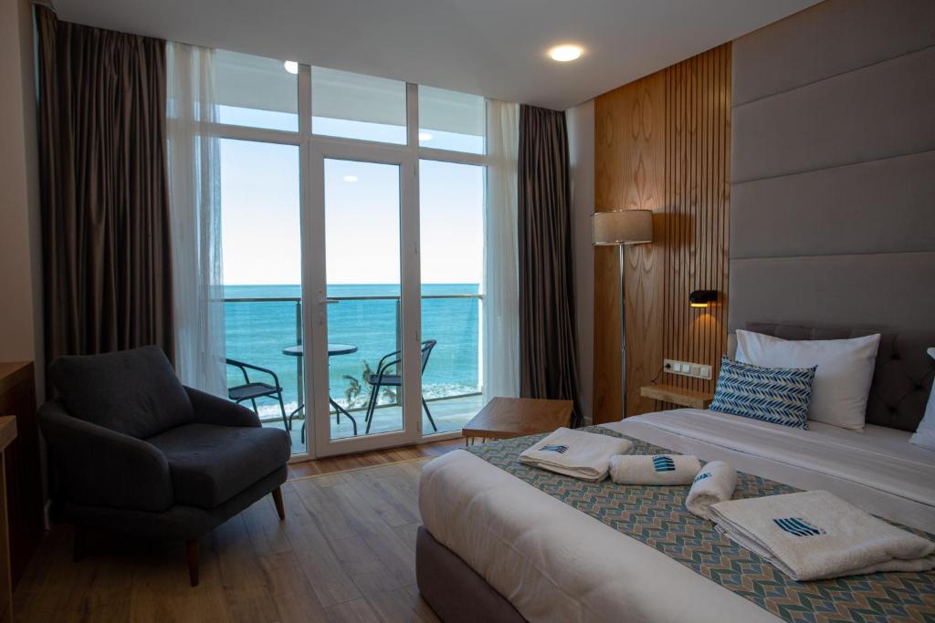 巴统Hotel Black Sea的酒店的客房 - 带一张床、椅子和窗户
