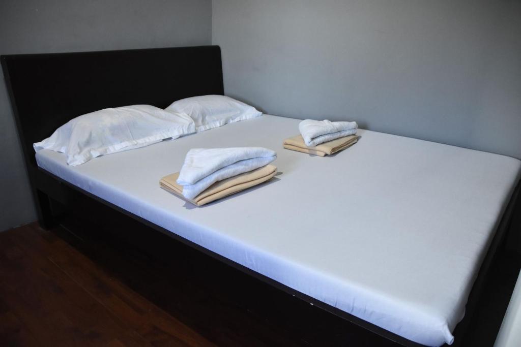 第波罗Bethany Suites的一张带白色床单和毛巾的床