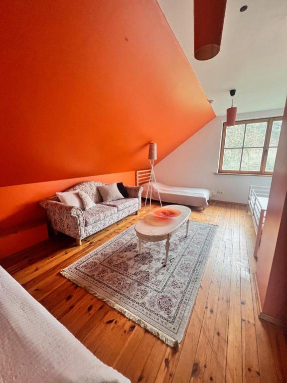 埃莱克特伦艾Farm hostel - The hause 1的橙色的客房设有沙发和桌子
