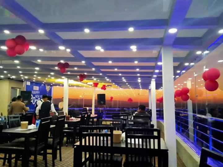 HeṭauḍāHotel Suryansh Pvt Ltd的一间带桌椅和红色气球的餐厅