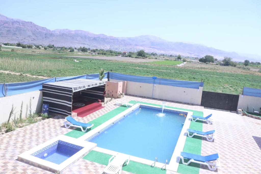 Aş ŞāfīWalaa Chalet的享有带躺椅的游泳池的顶部景致