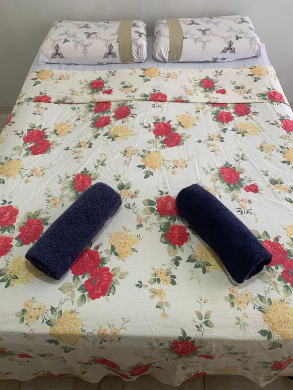 贝伦Quarto confortável perto de tudo 03的床上的2个枕头,上面有鲜花