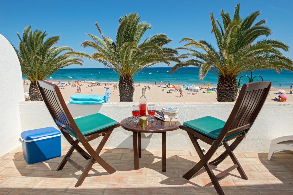 卢斯Luz Beach Apartments的棕榈树海滩上的桌椅