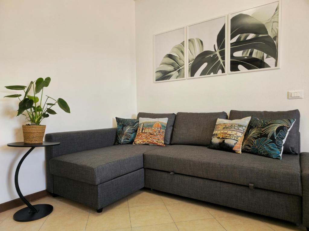 比森齐奥营Midori House Florence的客厅里放着灰色的长沙发,长着植物
