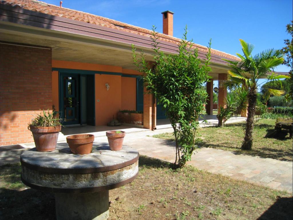 格拉达拉Villa Formica - Vista su Castello di Gradara的前面有三株盆栽植物的房子