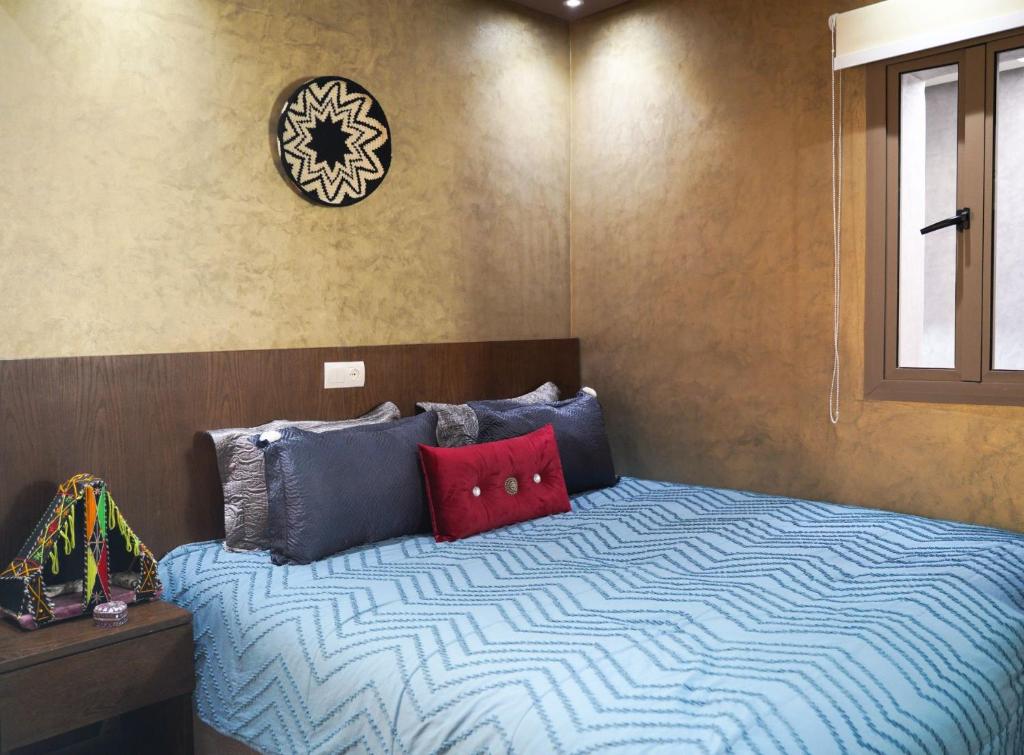 拉巴特Good Vibes的一间卧室配有蓝色和红色枕头的床