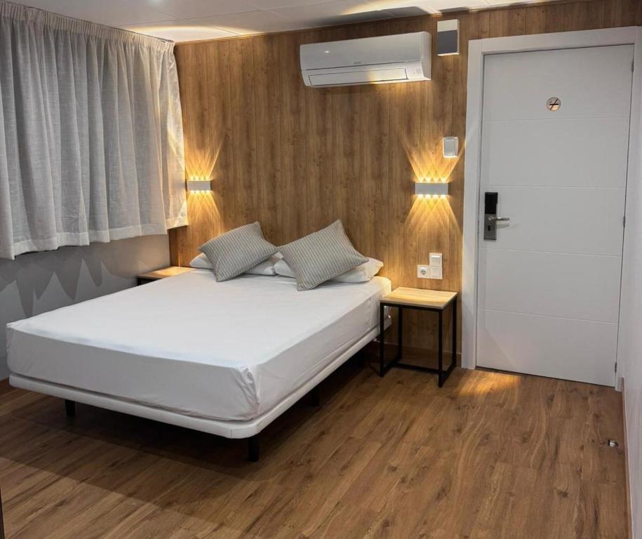 巴塞罗那梅蒂斯酒店的卧室配有白色的床、两张桌子和一扇窗户