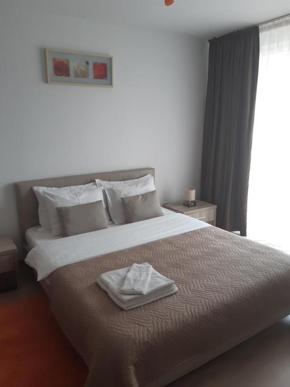布拉索夫Apartament Marcel - Coresi Mall的一间卧室配有一张大床,上面有毛巾