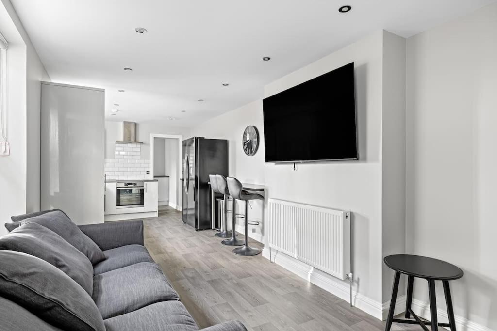 普里茅斯Brand New 5 Bedroom House的客厅配有沙发和墙上的电视